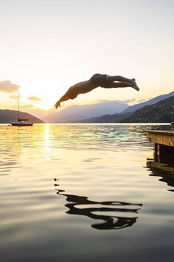 Ein erfrischender Sprung ins Wasser des Millstätter Sees bei Sonnenuntergang © Gert Perauer_MBN Tourismus