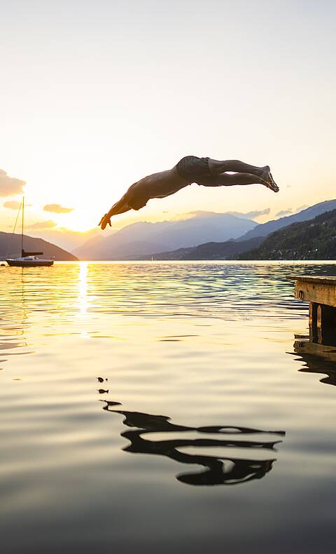 Ein erfrischender Sprung ins Wasser des Millstätter Sees bei Sonnenuntergang © Gert Perauer_MBN Tourismus